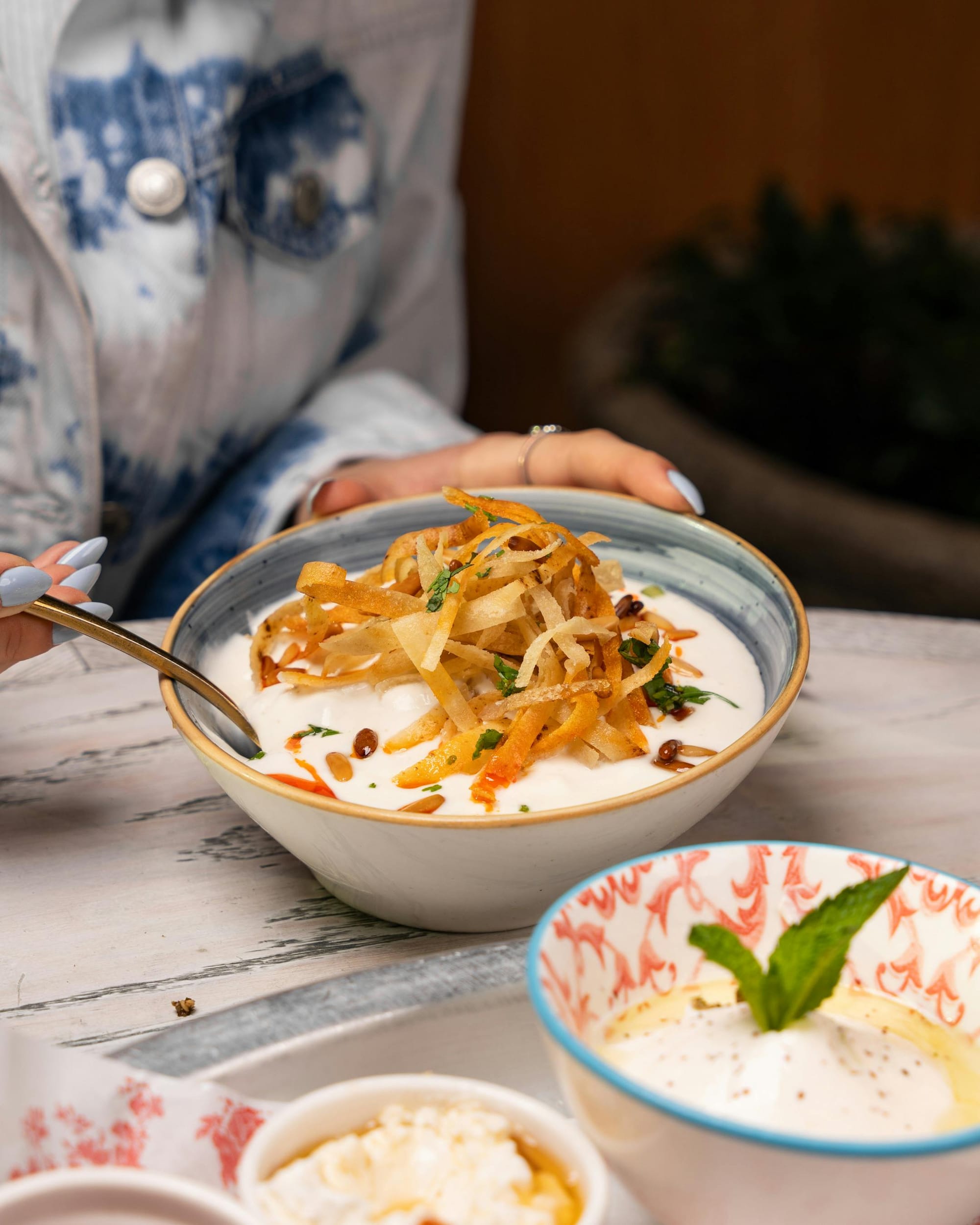 Persian mast-o-khiar yogurt with crispy onion and pine nut topping