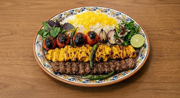 Festive Persian Nowruz platter with Joojeh and Koubideh kababs over saffron rice on a patterned plate